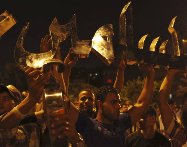 The prosecutor's office in Egypt has ordered the arrest of at least nine Muslim Brotherhood senior figures, including the movement's leader Mohamed Badie. The charges stem from the violence which occurred outside the Republican Guard headquarters where 55 people were killed on Monday, according to Egypt's state news agency MENA. The other senior Brotherhood officials who have been targeted for arrest include Badie's deputy Mahmoud Ezzat and party leaders Essam El-Erian and Mohamed El-Beltagi. The New York Times says that the Muslim Brotherhood denies that either Badie or the other party leaders have been arrested at this time. In an interview with RT-TV, spokesman Gehad El-Haddad repeatedly blasted the charges as an attempt by the authorities to break up a vigil by as many as 100,000 Brotherhood supporters who are demanding reinstatement of Mohamed Morsi as the “democratically elected president” of Egypt. Morsi was ousted by the army last week. The Huffington Post reports that in a telephone interview, El-Haddad claimed the charges were "nothing more than an attempt by the police state to dismantle the Rabaa protest." The Rabaa Adaweya mosque in northeast Cairo is where the vigil is occurring, and where Muslim Brotherhood leaders, including Mohamed Badie, are presumed to be held up. Indeed, El-Haddad confirmed that at least some of the leaders whose arrests were being sought were at the site of the protest. As has been widely reported, on Monday, 55 people were killed and hundreds injured when shots rang out during what the Muslim Brotherhood called a peaceful protest outside the Republican Guards barracks. It is believed that Morsi himself is being held incommunicado in those selfsame barracks. After the Monday shooting, which the Muslim Brotherhood has labeled a “massacre,” the Brotherhood did, in fact, call upon all Egyptians to "rise up against those who want to steal their revolution with tanks and armored vehicles, even over the dead bodies of the people," according to The Jerusalem Post. The army, on the other hand, blamed "a terrorist group" for attempting to storm the Republican Guard compound. It said that one army officer had been killed and 40 others wounded. Soldiers only returned fire after being attacked by armed assailants, a military source told The New York Times. As for the US, the State Department has condemned Monday's shooting and called upon the Egyptian army to exercise "maximum restraint" in handling protesters. Egypt's newly appointed Prime Minister Hazem El-Beblawi was set to begin forming a cabinet Wednesday. He has said he will offer the Brotherhood significant positions in a new government, according to the BBC. The Daily Telegraph reports that a Brotherhood spokesman dismissed any talk of joining a military-backed administration out of hand. He said that the notion of “national reconciliation” is "irrelevant." He spoke on condition of anonymity because of concerns for his personal security.